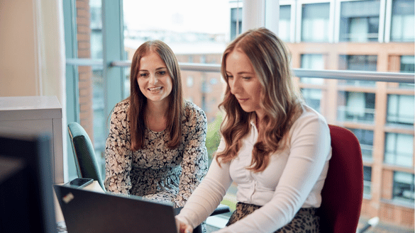 Two members of the HR team work on a project together at Head Office