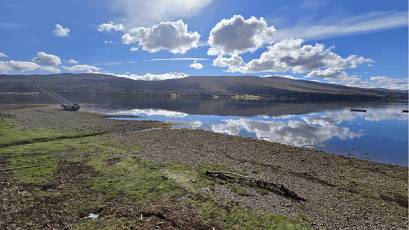 An image of loch near Fort William in Scotland, taken on a sunny day with clouds reflected in the water