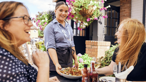 Waiting staff serving food to a table outside