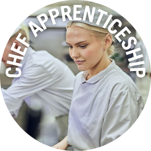 Chef apprentice in a kitchen, with another chef in the background. Banner reads 'Chef Apprenticeships'
