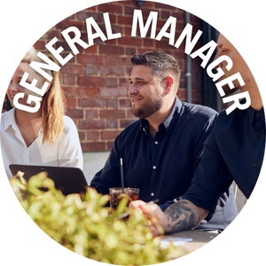 General Manager sits with their team at an outside table. Link to General Manager Jobs