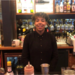Female bartender standing behind bar