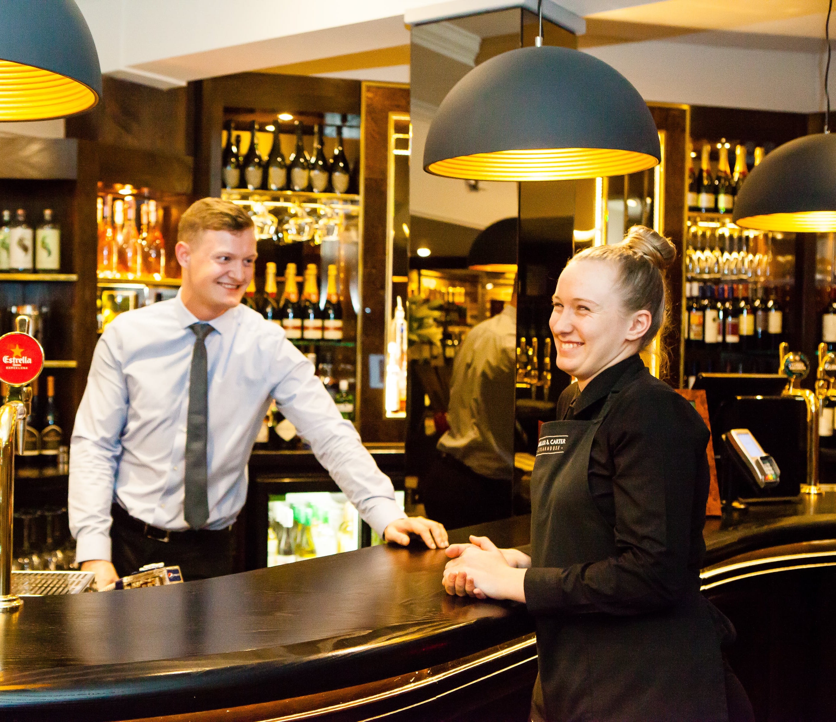 waiter and manager standing at pub bar