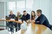 group of people sat in an office at a long desk