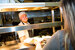 man in chef whites passing plated food to a woman