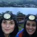 two females standing in front of a lake with head touches on