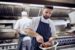 chef with chef hat mixing up salad in a bowl in a kitchen 