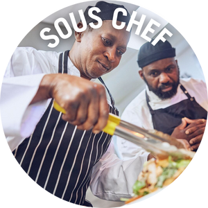 Sous Chef plates up a salad in an All Bar One kitchen, with another chef in the background. 