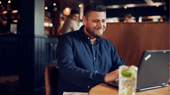 General Manager in a Castle pub works at a laptop.