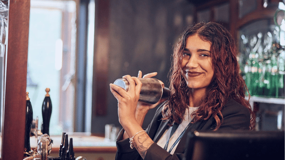 A retail graduate makes a drink in a Nicholson's bar