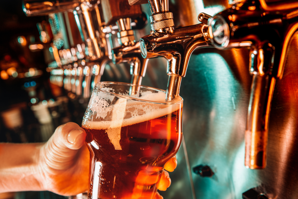 Hand pouring pint at a bar in a summer job at a pub