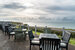 tables and chairs sat on decking by the coastline