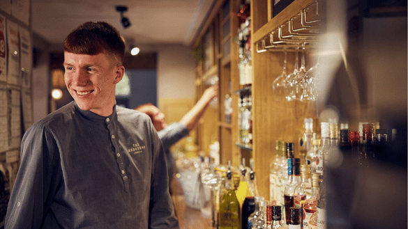 Bar team member at a Vintage Inn stands behind the bar