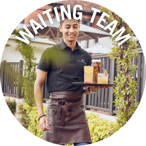 Waiting team member, takes drinks to guests outside with pub in the background. Banner reads 'waiting team'