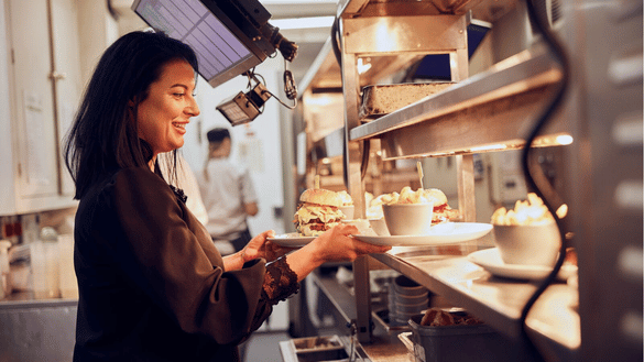 An assistant manager in Vintage Inns takes food from the kitchen