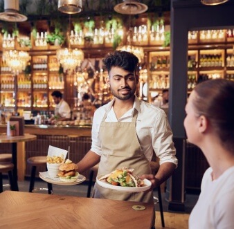 A waiter serving food to a girl