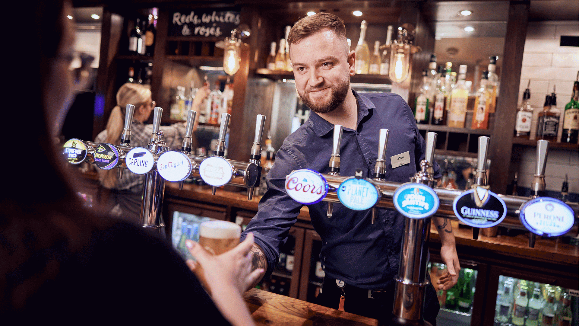 2 bartenders shaking cocktails behind bar
