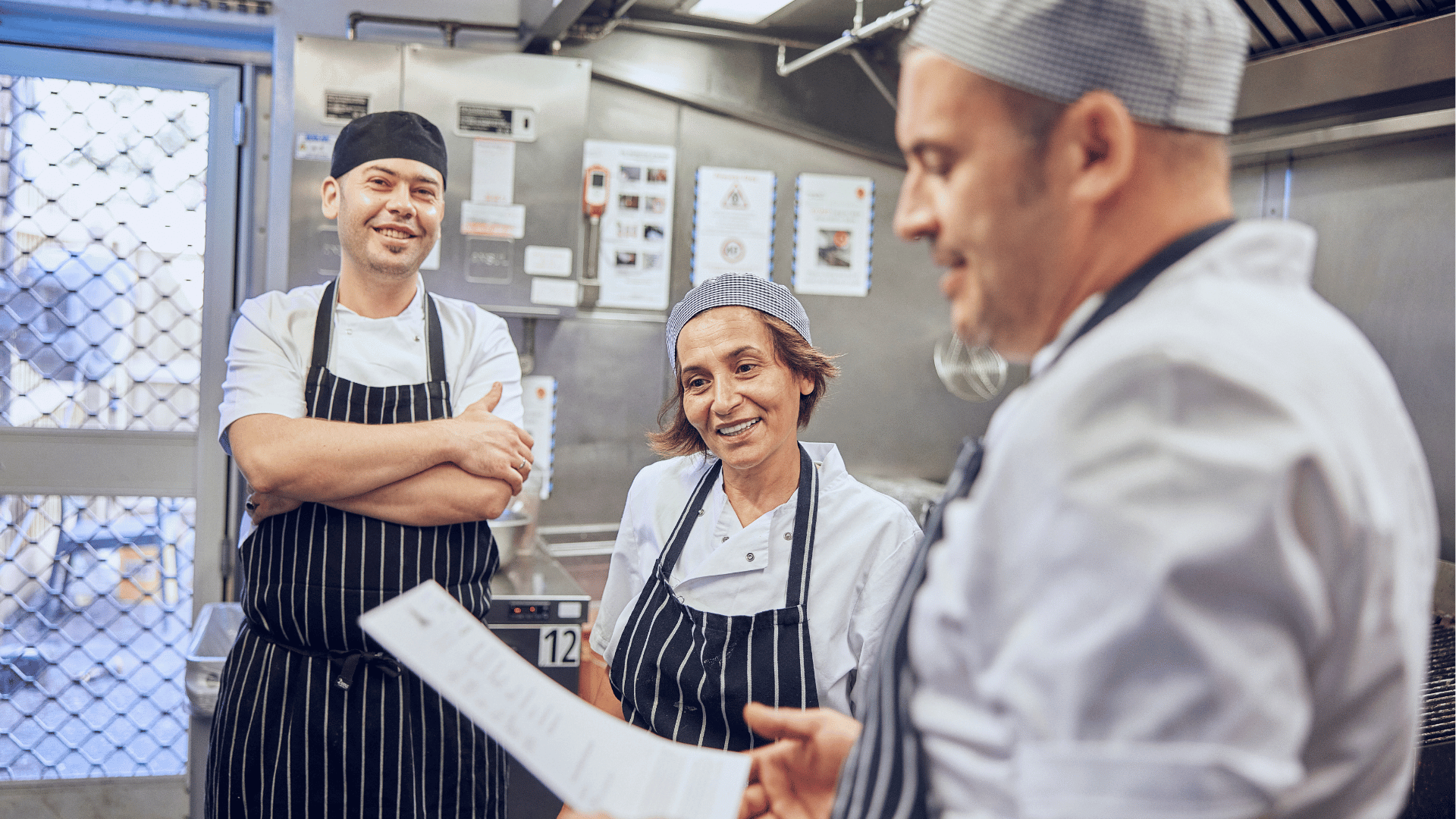 blurred images of a chef in their whites cooking in a kitchen