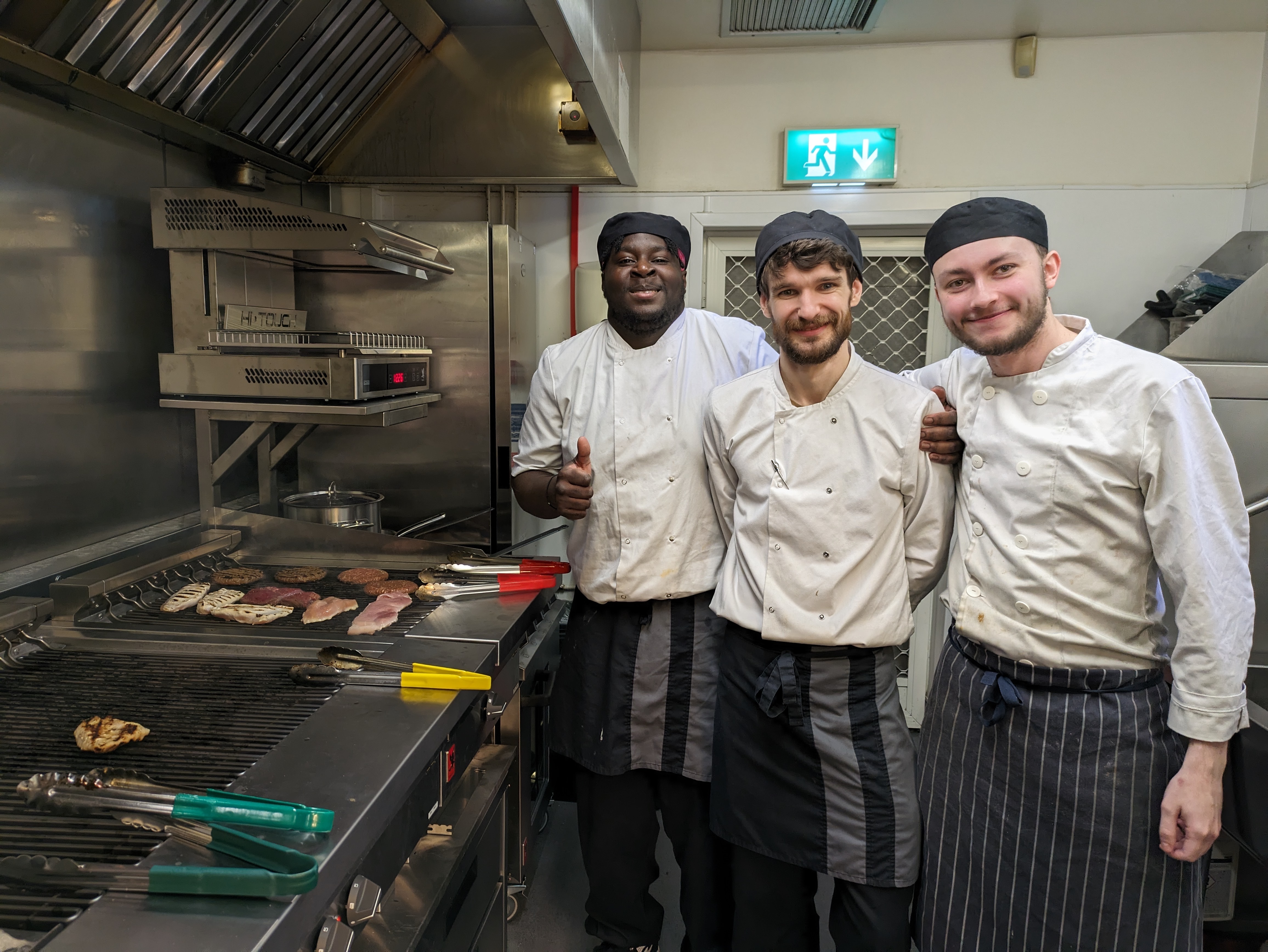 electric kitchen at m&b with three chefs smiling
