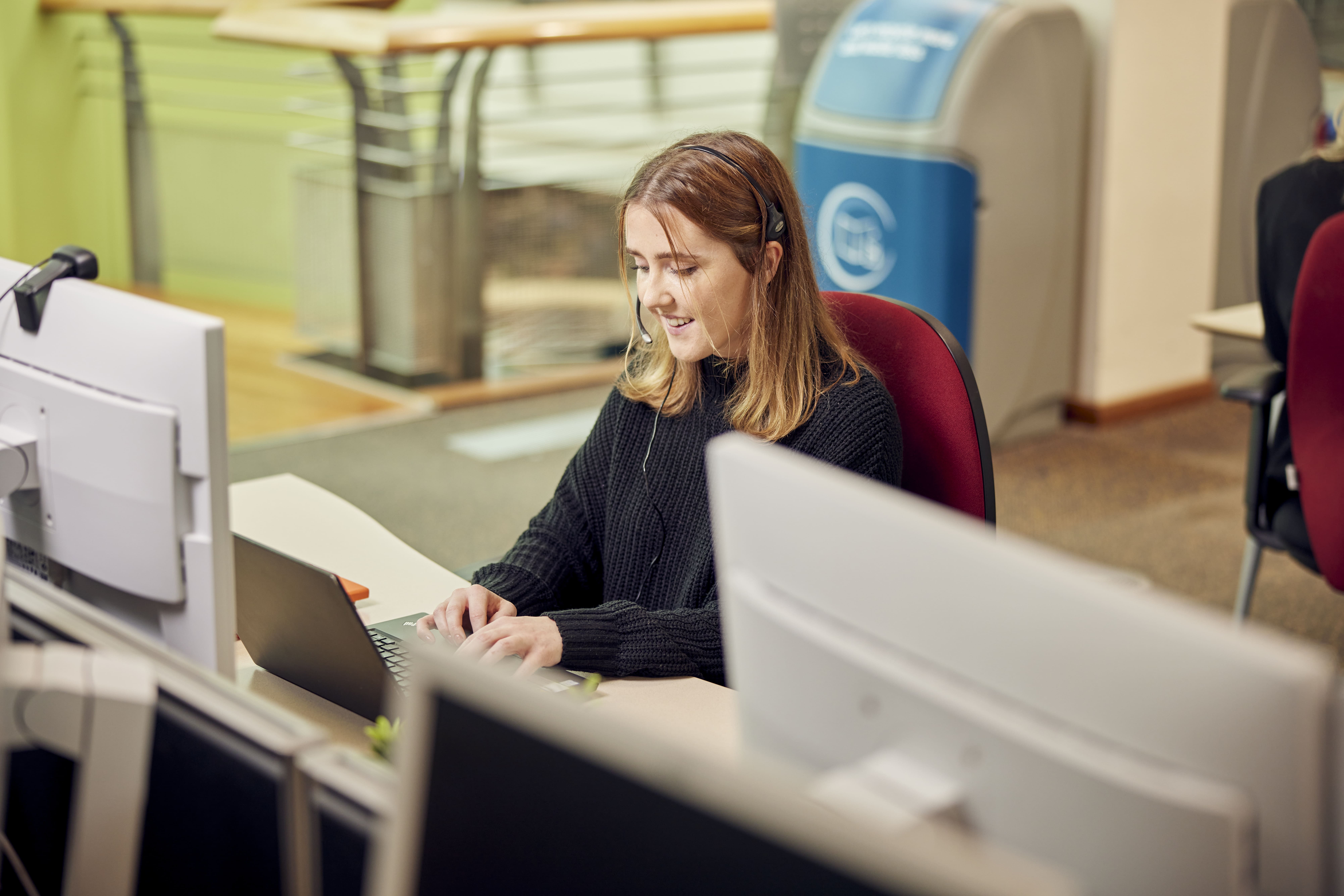 graduate smiling at their computer