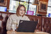 smiling lady on laptop sitting at pub