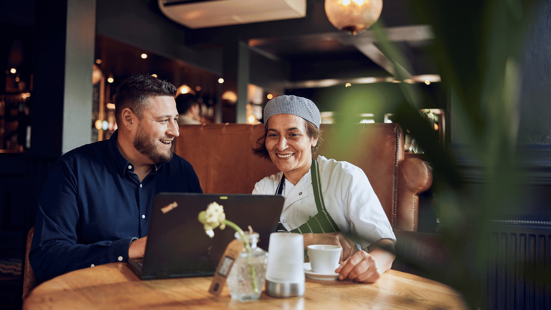 chef working in a kitchen with three lights hanging over him