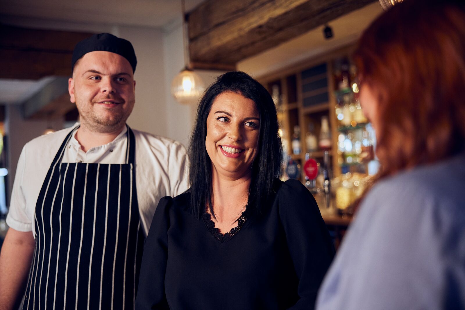 smiling deputy manager and chef in pub 