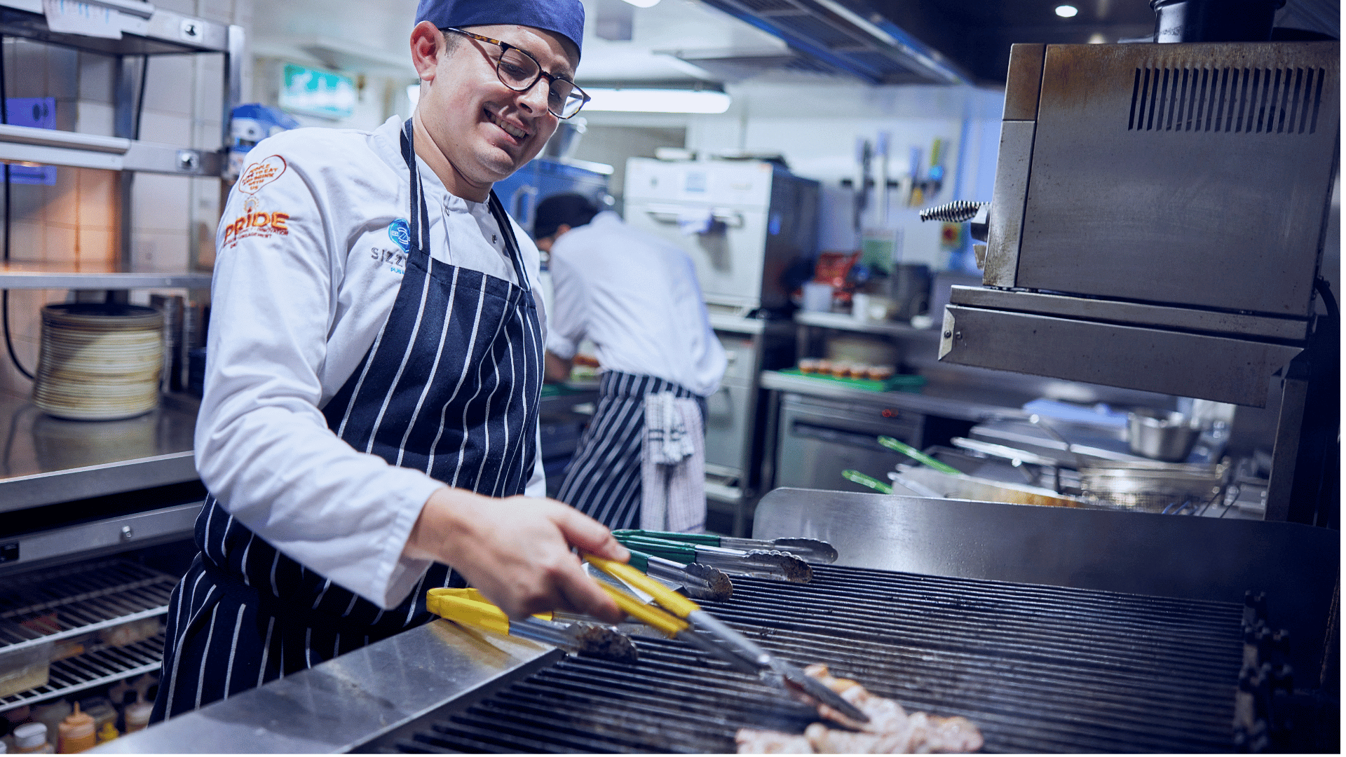 chefs arms around each other in kitchen