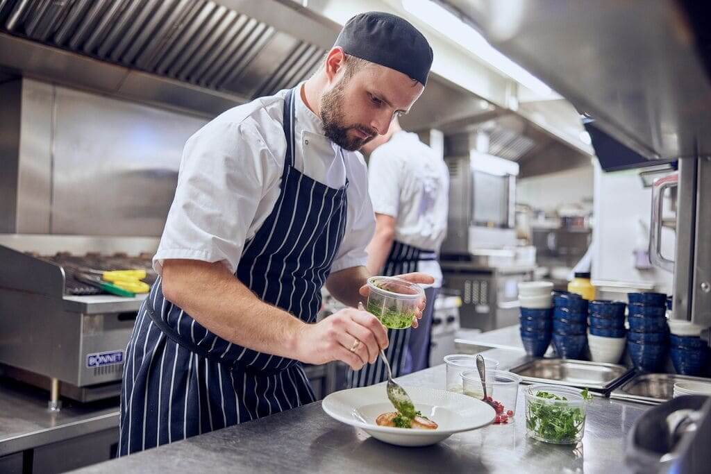 image of kitchen assistants plating up food 