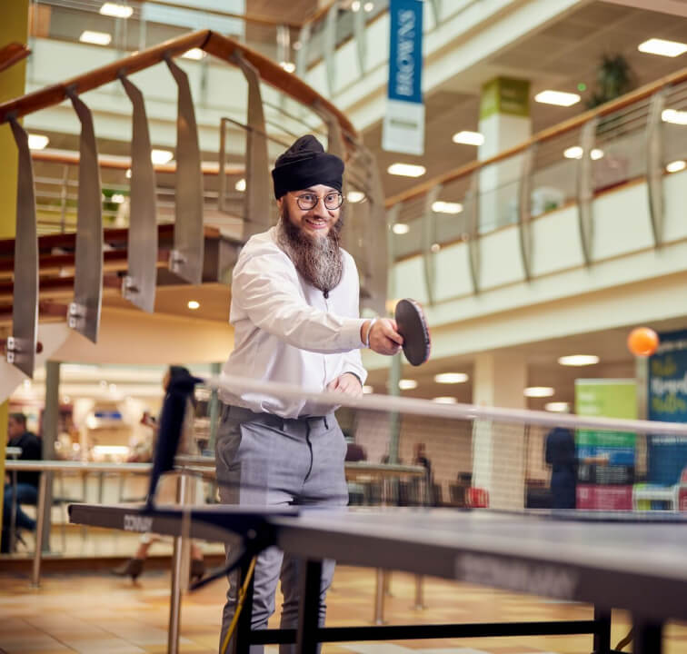 two male employees playing ping pong