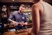 image of bartender pouring a drink for guest and smiling