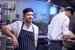 image of kitchen team cooking in the kitchen wearing aprons and hats
