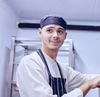 Kitchen assistant organising metal containers