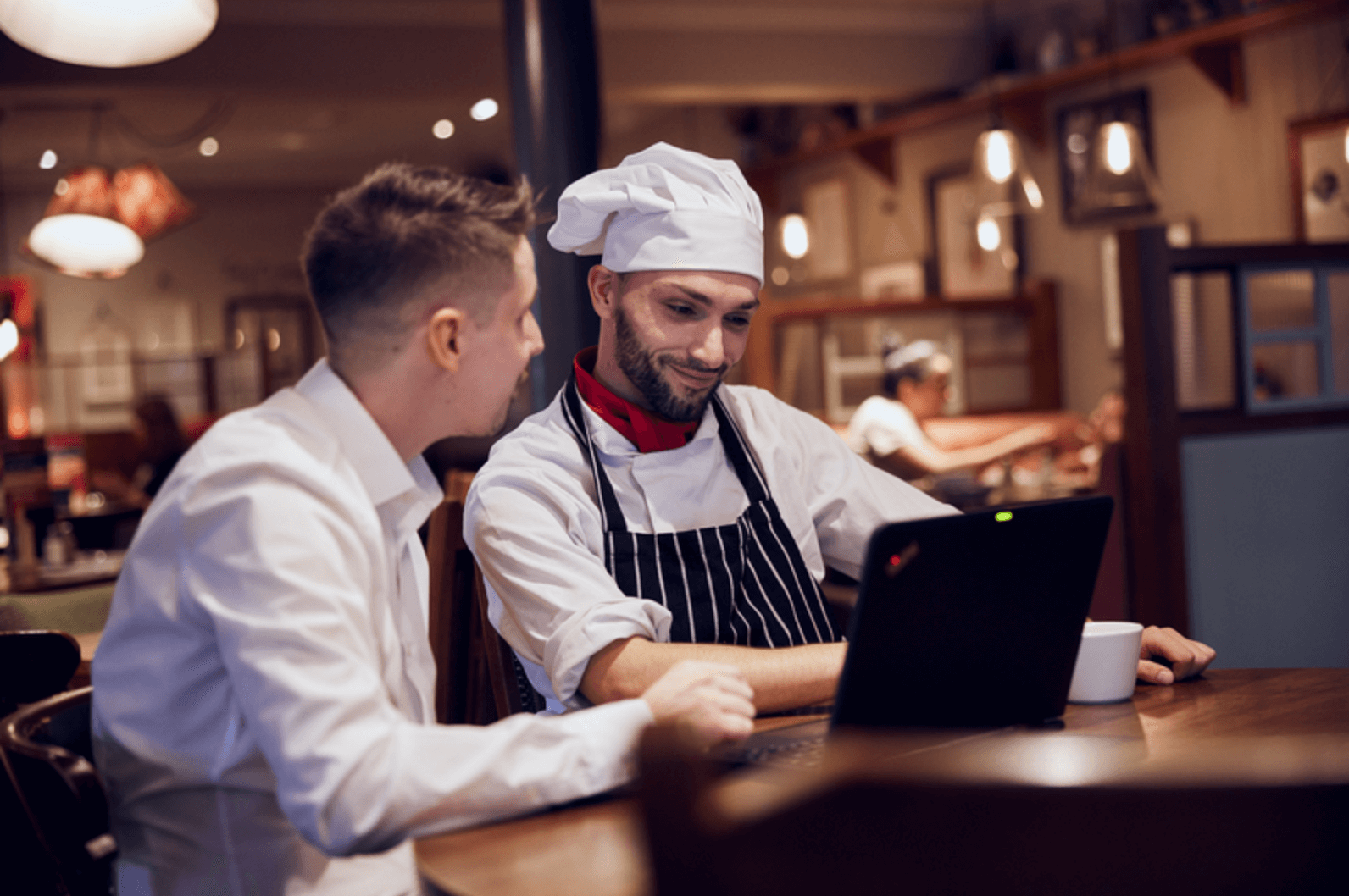 image of M&B pub staff talking to each other standing at a till 