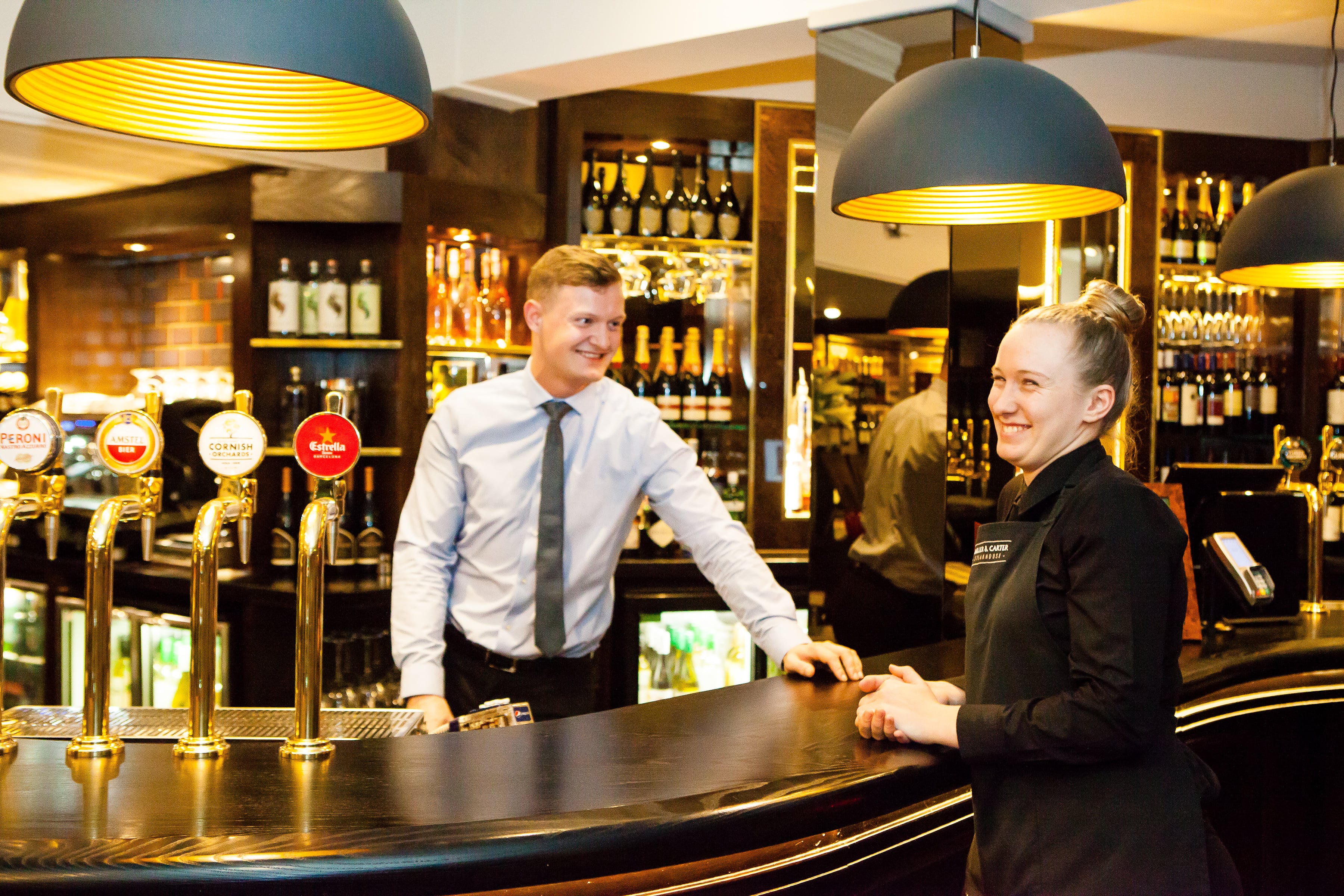 waiter and manager standing at pub bar