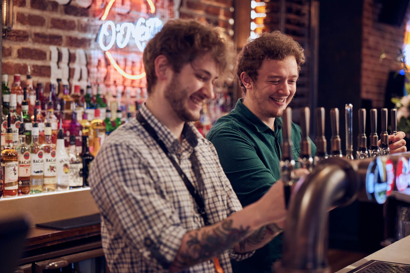 Two barmen pouring pints
