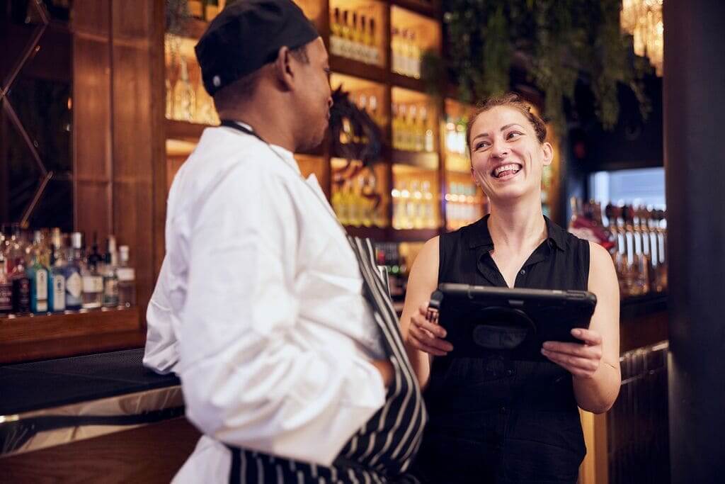 general manager speaking to chef whilst holding an IPAD 