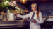 two girls standing at a restaurant bar laughing