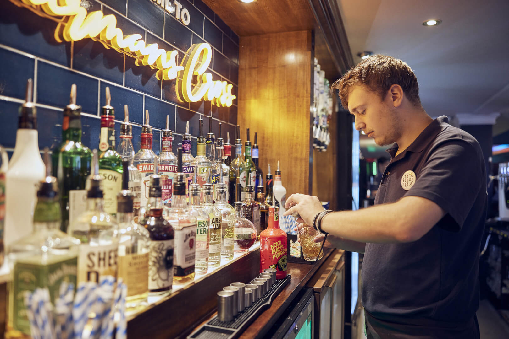 image of bartender pouring a drink at the bar 