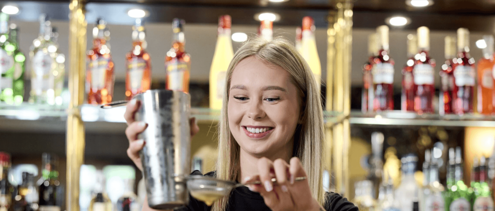 image of pesto bartender pouring a drink with a smile 