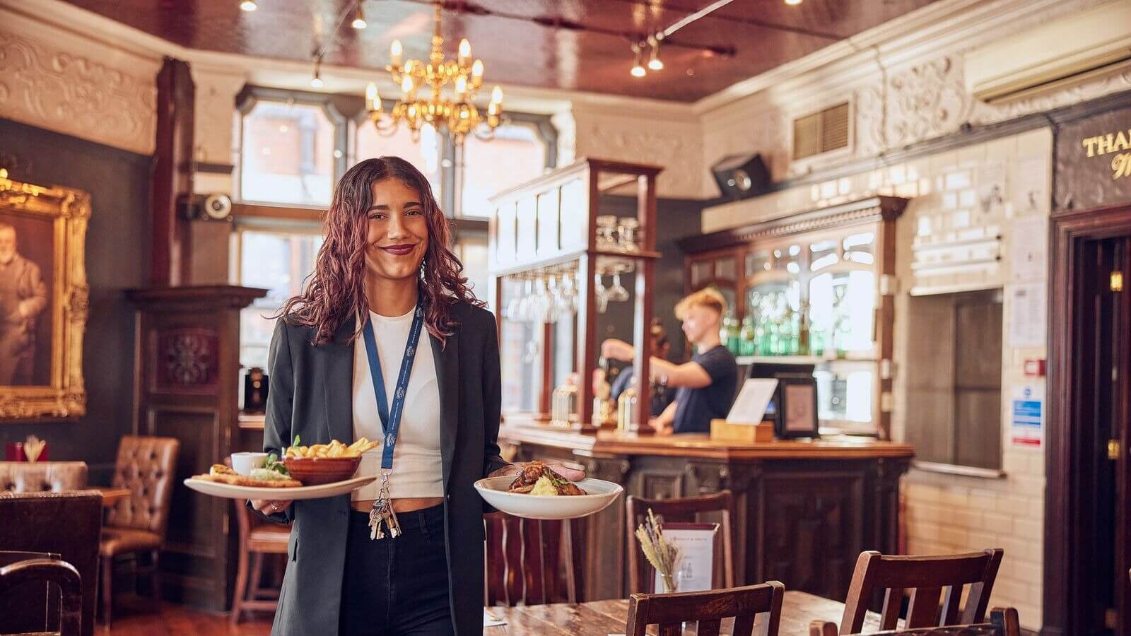 image of wait staff bringing food to table with a smile 