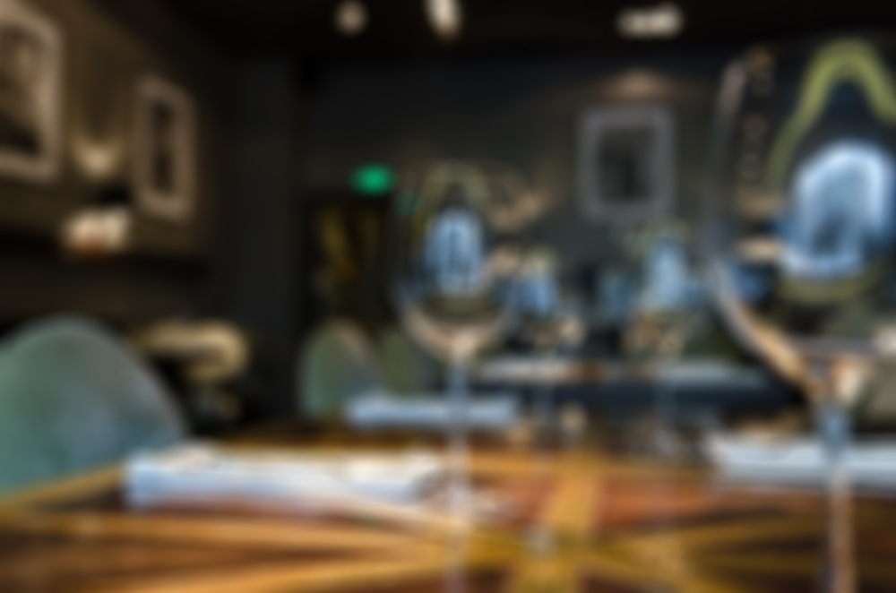 blurred table and chairs with wine glasses on top