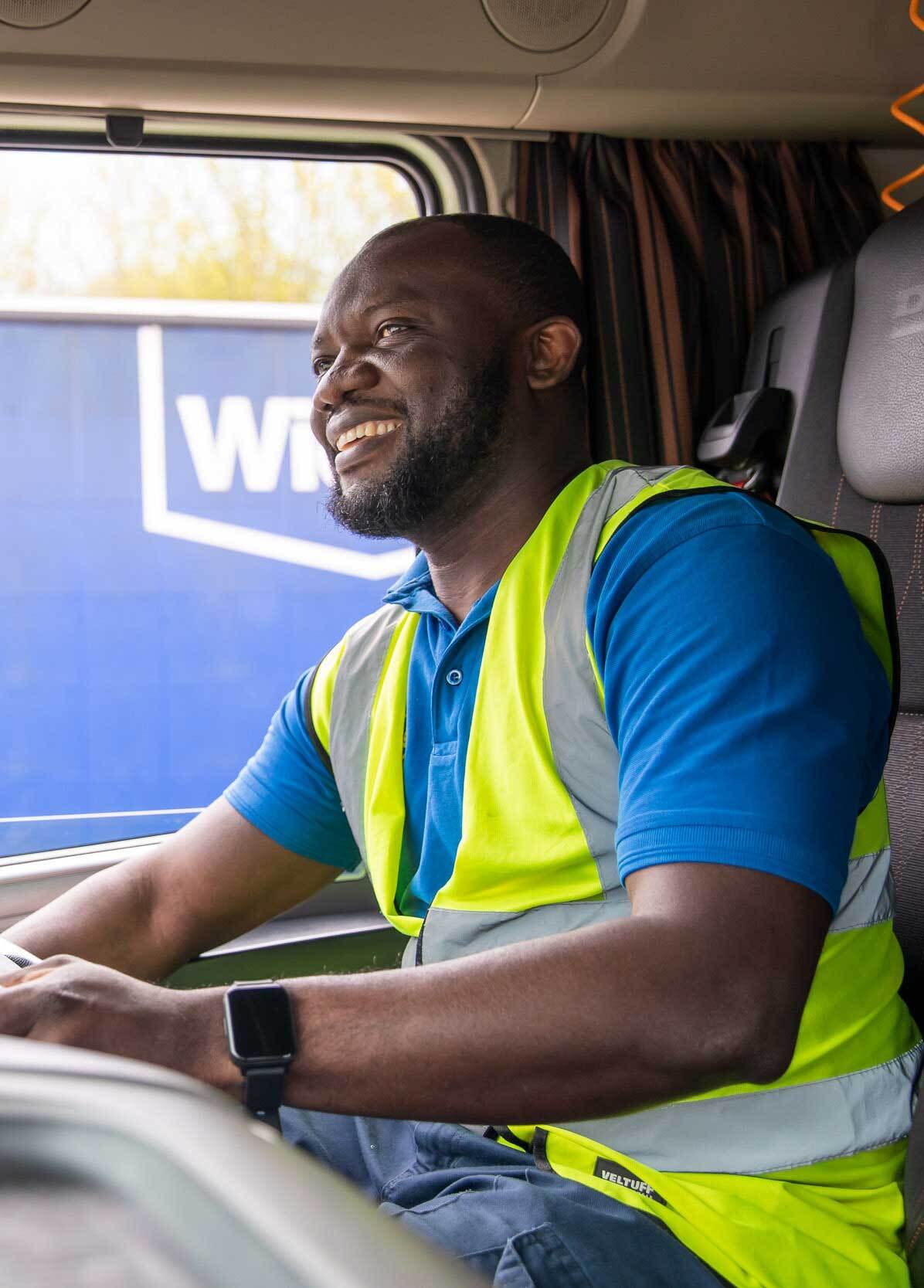 A man driving his van smiling happily