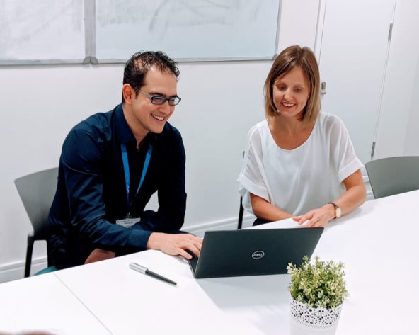 pricing analytics career - two people smiling and looking at laptop 