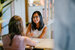 two women sat at a desk talking