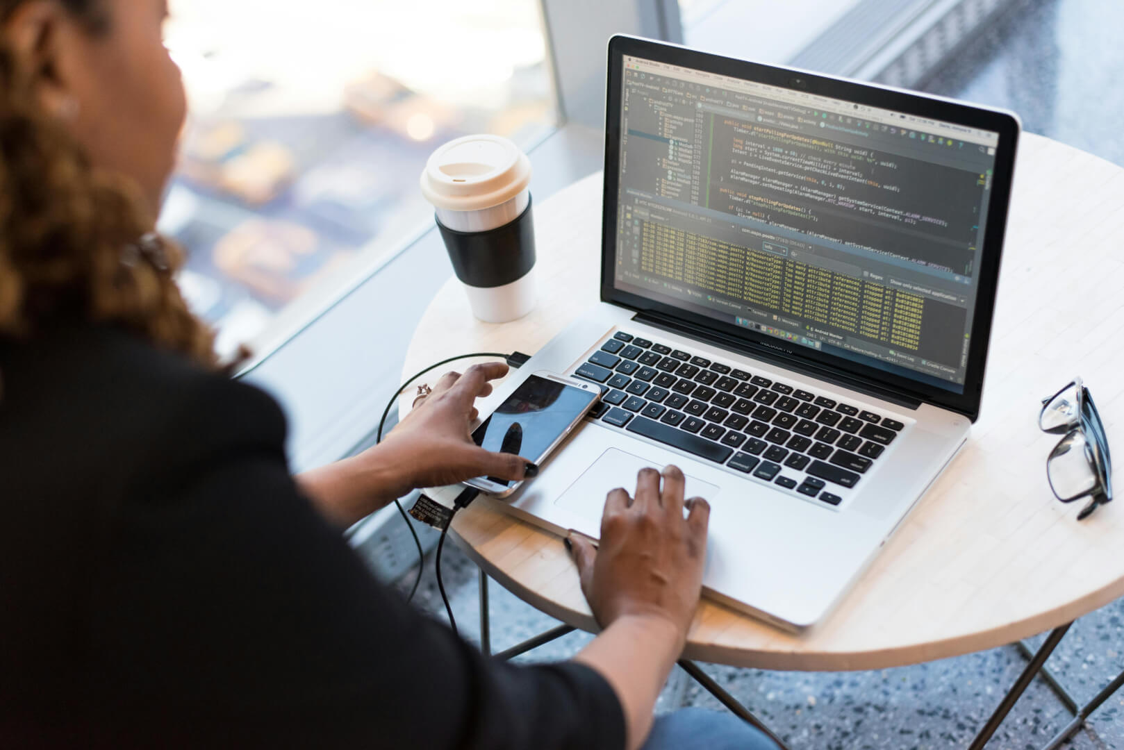 A woman sat a desk working on a laptop