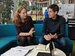 Two people sat on a sofa talking