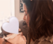 A photo of Carla holding her baby with the baby's face covered.