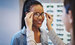 female smiling getting optical eyewear fitted by another female