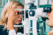 women using optical equipment to examine another women's eye